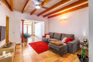 uma sala de estar com um sofá e um tapete vermelho em Can Mateu em Campanet