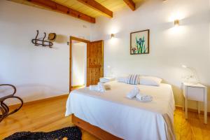 um quarto com uma cama branca e toalhas em Can Mateu em Campanet