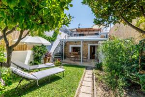um jardim com duas espreguiçadeiras e uma casa em Can Mateu em Campanet