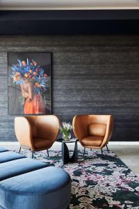 a lobby with two chairs and a painting on the wall at Adina Apartment Hotel Melbourne Flinders Street in Melbourne