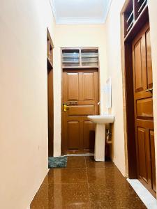La salle de bains est pourvue d'un lavabo et d'une porte. dans l'établissement Nakupenda, à Mazizini