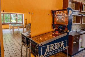 Una máquina de videojuegos en una cocina contigua a una habitación en Lizard House, en Cevio