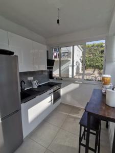 a kitchen with white appliances and a table and a window at Paulina Harmony Rooms in Seget Vranjica