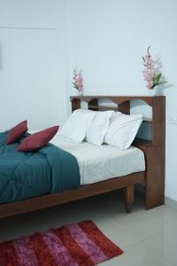 a bedroom with a bed with white sheets and red pillows at Wind Valley in Ramakkalmedu