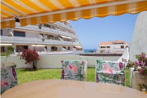 a table and chairs in front of a cruise ship at MAapartmentsES Garden City in Playa Fañabe