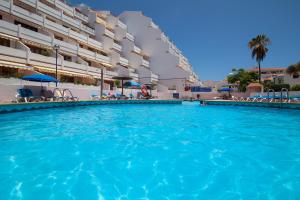 a large swimming pool in front of a building at MAapartmentsES Garden City in Playa Fañabe