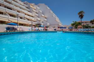 una grande piscina di fronte a un edificio di MAapartmentsES Garden City a Playa Fañabe