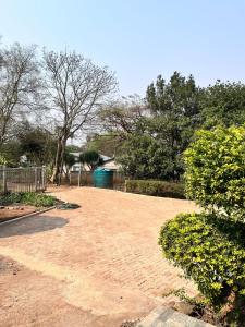a large dirt yard with a fence and trees at Sherotha Accommodation in Louis Trichardt
