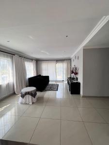 a large white living room with a couch and a table at Sherotha Accommodation in Louis Trichardt