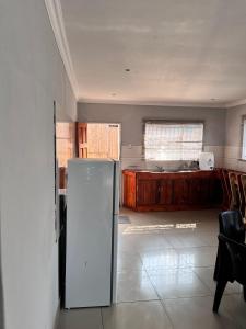 a kitchen with a refrigerator in the middle of a room at Sherotha Accommodation in Louis Trichardt