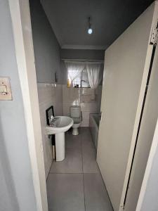 a small bathroom with a sink and a toilet at Sherotha Accommodation in Louis Trichardt