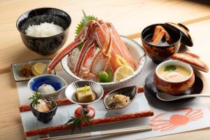 uma mesa com um prato de comida e tigelas de comida em 一日一組の隠れ宿　てらかわ em Kinosaki
