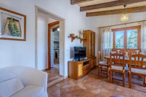 a living room with a couch and a table with a tv at Chalet Turó in Cala Santanyi