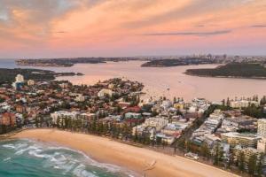 an aerial view of a beach with buildings and the ocean at Perfect Manly Retreat. in Sydney
