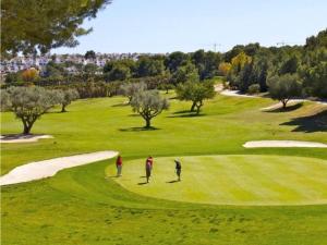 two people playing golf on a golf course at Luxe Appartement Orihuela Costa - Villamartin -Aire Residencial - green and pool view in Orihuela Costa