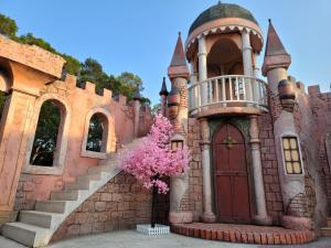 un castillo con un árbol delante de él en 綠意山莊 Greenforest, en Yuanli