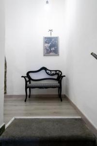 um banco sentado numa sala com uma parede branca em Casa vacanze S.Andrea em Viterbo