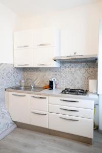 uma cozinha branca com um lavatório e um fogão em Casa vacanze S.Andrea em Viterbo