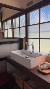 a bathroom with a large white sink with windows at NORD 3 自然豊かな家 - Manji Village - in Iwamizawa