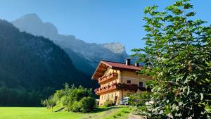 a building on a hill with mountains in the background at Alpen Appartements Oberlehengut - HIDEAWAY in Werfenweng