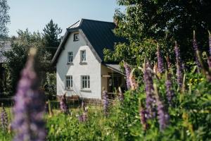 una casa blanca con techo negro y flores púrpuras en Mezi vrchy, en Jablonné v Podještědí