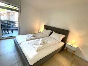 Una cama con sábanas blancas y almohadas en un dormitorio en homy City Lodge in Feldkirch, Grenznähe und doch Zentral en Feldkirch