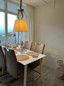 mesa de comedor con sillas y luz en Ferienwohnung an der Ostsee, en Heiligenhafen