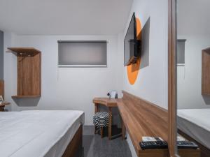 een kamer met 2 bedden, een bureau en een televisie bij Cove Accordia Residence in Jakarta