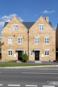 a large brick building with white windows on a street at Contractors & Corporates - New Townhouse 13 Min From STN in Bishops Stortford