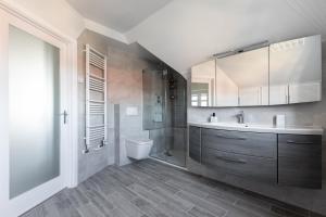 a bathroom with a sink and a shower and a toilet at Stansted Airport - Executive Serviced Home With Parking in Bishops Stortford