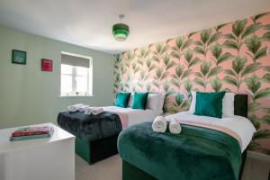 a hotel room with two beds and a couch at Stansted Airport - Executive Serviced Home With Parking in Bishops Stortford