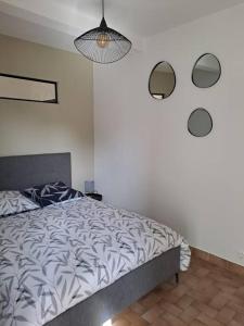 1 dormitorio con 1 cama y luz colgante en Chez Béatrice, en Saint-Jouan-des-Guérets