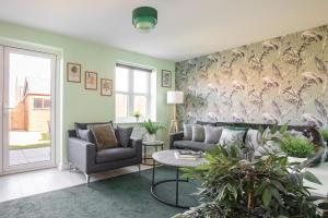 a living room with a couch and a table at Unwind in Style - Entire Home with Parking and Stunning Garden, Just Minutes from the Airport! in Bishops Stortford