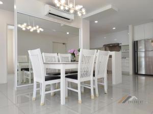 a dining room with a white table and white chairs at Evernent's Homestay @ The Wharf in Miri