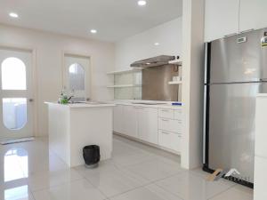 a kitchen with a stainless steel refrigerator and white cabinets at Evernent's Homestay @ The Wharf in Miri