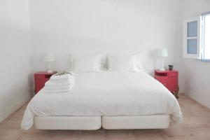 a bedroom with a white bed with two red night stands at o meu monte in Évora
