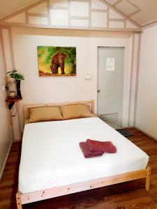 Jungle View Resort في كو تشانغ: غرفة نوم بسرير ابيض مع لوحة على الحائط