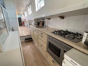 a kitchen with a stove top oven next to a bathroom at Spacious homely house boat in Amsterdam
