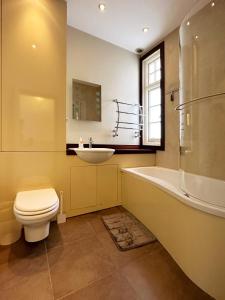 a bathroom with a toilet and a sink and a tub at Kim's 3 Bedroom House with Free On-Street Parking in Palmers Green