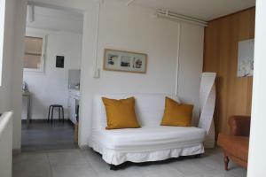 a white couch with two pillows on it in a living room at NEB-THUN Studio am Thunersee in Thun