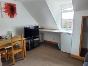 a living room with a desk and a window at Sunnyside Accommodation in Skegness