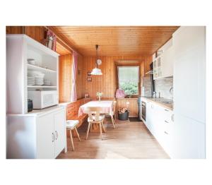 a kitchen with white cabinets and a table in it at Apartment Toni in Sarntal