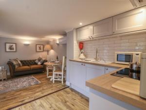 a kitchen and living room with a couch at Holly House Studio in Sudbury