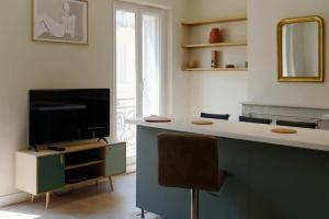 uma sala de estar com uma televisão e uma secretária com uma cadeira em [Gourjon 2] - T2 fonctionnel emplacement idéal Joliette em Marselha