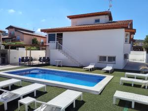 a villa with a swimming pool in front of a house at Mar i Cel -Chalet con piscina privada- in Peniscola