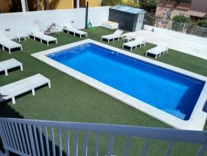 a swimming pool on top of a balcony with lounge chairs at Mar i Cel -Chalet con piscina privada- in Peniscola
