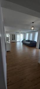 uma ampla sala de estar com um sofá e piso em madeira em Vila Andrea em Oradea