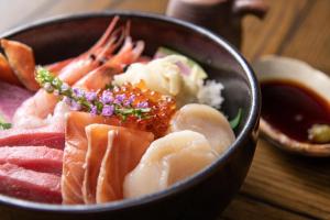 a bowl of food with sushi and other foods at Yu Kiroro, Ski-in Ski-out Luxury Residences in Akaigawa