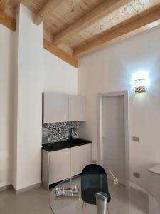 une cuisine avec une table en verre et une chaise noire dans l'établissement La Dimora del Duca, à Palma di Montechiaro
