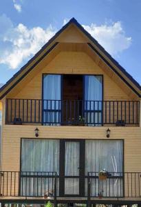 a house with a balcony on top of it at Cottage Mzispira/Cottage sunny side in Sioni